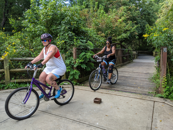 Two people riding bikes on Riverwalk greenway